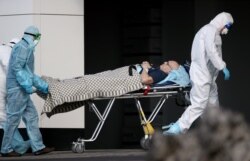 Ресейлік дәрігерлер коронавирус жұқтырған адамды әкетіп барады. Мәскеу, 4 сәуір 2020 жыл.