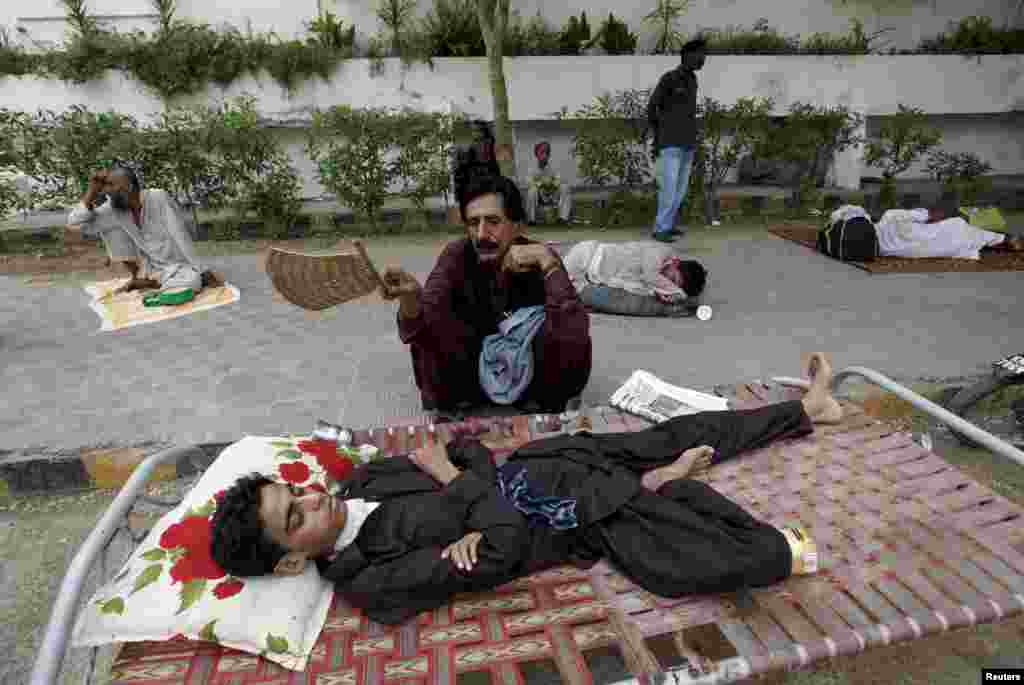 Пакистан. Чоловік дме на свого сина за допомогою віяла під час очікування в черзі на медичне обстеження біля медичного центру в Карачі, 23 червня 2015 року