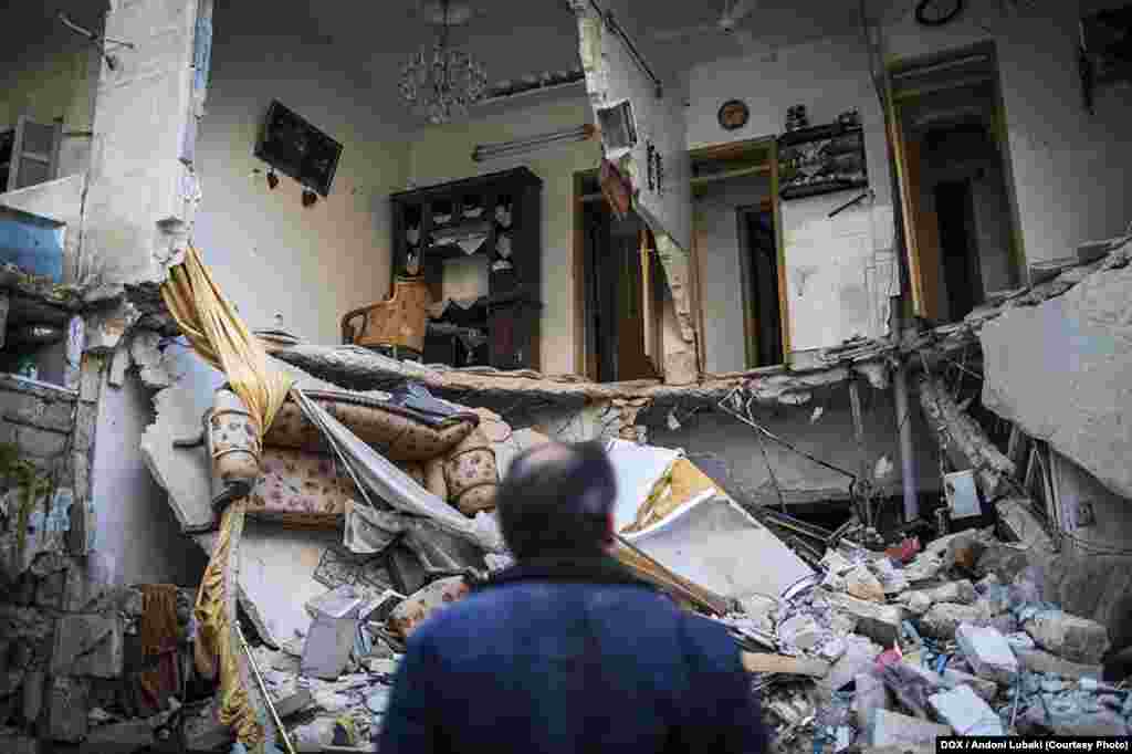 A man looks at a house destroyed by a government air raid in the al-Izaah neighborhood of Aleppo, Syria. This district, formerly densely populated, was hit extremely hard due to its position on a hill near a TV station. January 3, 2013&nbsp;