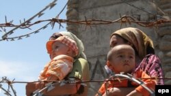 Ethnic Uzbek refugees stand at the Kyrgyz-Uzbek border crossing near Osh. Some 400,000 people have fled the violence. 