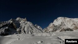 FILE: The world's second largest mountain, the 8,611 meter high K2 (seen in the distance), and the 8,051 meter high Broad Peak (R), are illuminated by the moon.