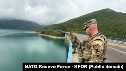 Vojnik KFOR-a i pripadnici KBS-a stoje na jednom od mostova na jezeru Gazivode, gde su u toku pretrage, 29. jula 2025. godine.