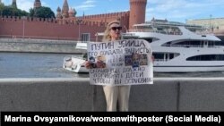 Marina Ovsiannikova protestează la Moscova cu o pancartă pe care scrie: „Putin este un criminal, soldații lui sunt fasciști. 352 de copii au murit. Câți mai trebuie să moară ca să se oprești?”, Moscova, Rusia, 15 iulie 2022