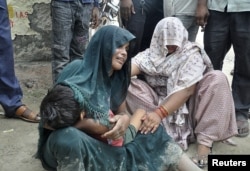 Një grua ngushëllohet teksa vajton pasi djali i saj vdiq nga ikja në rrëmujë në një festival fetar në Indi, 2 korrik 2024.