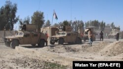 Afghan security forces patrol the outskirts of Helmand.