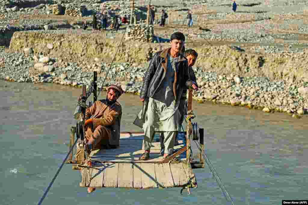 Afghans ride a zipline to cross the Kokcha River in the Yaftal Sufla district of Badakhshan Province.