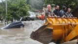 Людей вытаскивают ковшом экскаватора во время наводнения в Сочи в 2015 году, архивная фотография