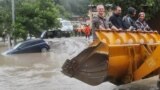 RUSSIA -- SOCHI, JULY 5, 2021: Men climb in an excavator bucket in the flood-hit neighbourhood of Kudepsta, Khostinsky District. Intense rains have sparked a drastic surge in water levels of the local rivers