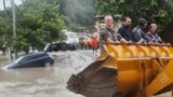 RUSSIA -- SOCHI, JULY 5, 2021: Men climb in an excavator bucket in the flood-hit neighbourhood of Kudepsta, Khostinsky District. Intense rains have sparked a drastic surge in water levels of the local rivers