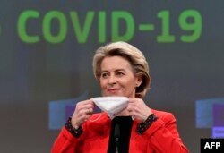 Ursula von der Leyen își scoate masca de protecție la o conferință de presă din martie 2021 referitoare la certificatul de vaccinare Covid-19.