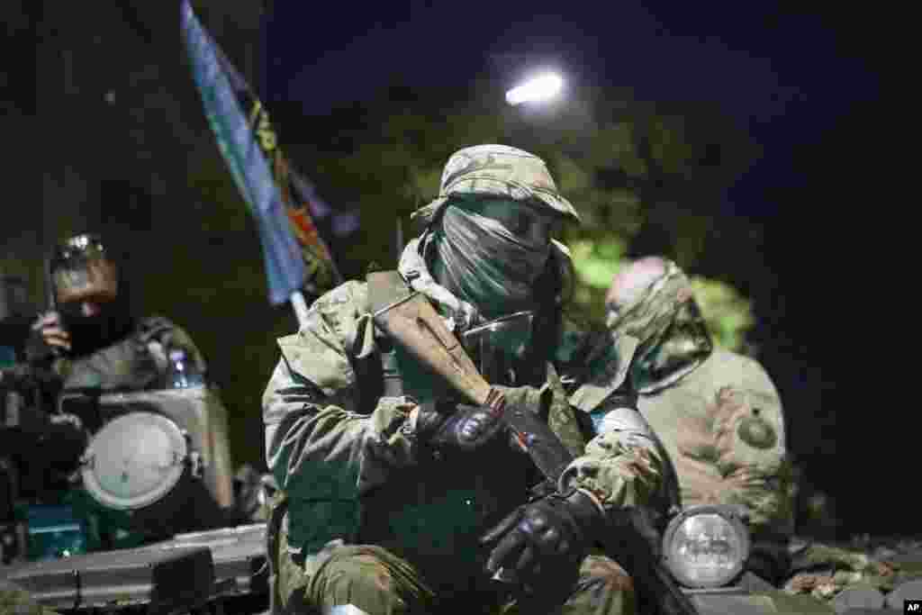 Membrii companiei militare Wagner stau în vârful unui tanc pe o stradă din Rostov-pe-Don, Rusia, sâmbătă, 24 iunie 2023, înainte de a părăsi o zonă din sediul Districtului Militar de Sud.