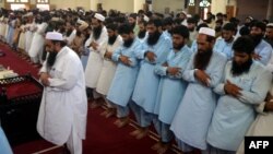 In this handout photograph released by Jamaat-ud-Dawa on July 30, Hafiz Saeed (front L), leads the absentia funeral prayer in Lahore for Afghanistan's Taliban chief Mullah Omar.