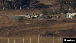 An armed group is seen on the Syrian side near the Quneitra border crossing between the Israeli-controlled Golan Heights and Syria August 28, 2014