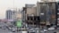 Vehicles drive past a burned-out building destroyed during the unrest in the Tehran on January 19.