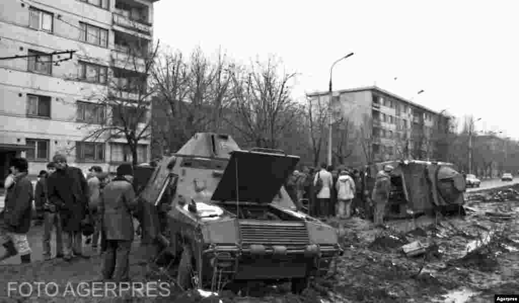 București, 23-24 decembrie. Mașinile blindate în care s-au aflat victimele diversiunii de la Ministerul Apărării (aflat în Drumul Taberei) membrii ai trupelor USLA. Cadavrele lor au rămas mai mult timp pe caldarâm și au fost profanate de trecători, deși comandații lor, cei care îi chemaseră la Ministerul Apărării, știau că cine sunt.&nbsp;&nbsp;