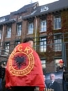 Një protestues i mbështjellë me flamur të Ushtrisë Çlirimtare të Kosovës, qëndron pranë selisë së Dhomave të Specializuara të Kosovës në Hagë, teksa gjykatësi shqipton aktgjykimin ndaj ish-krerëve të UÇK-së, në Hagë, Holandë, 16 shtator 2026.