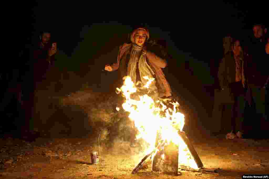 An Iranian woman jumps over a bonfire during a celebration, known as &quot;Chaharshanbe Souri,&quot; or Wednesday Feast, marking the eve of the last Wednesday of the solar Persian year, in Tehran, Iran, Tuesday, March 19, 2019.&nbsp; &nbsp;