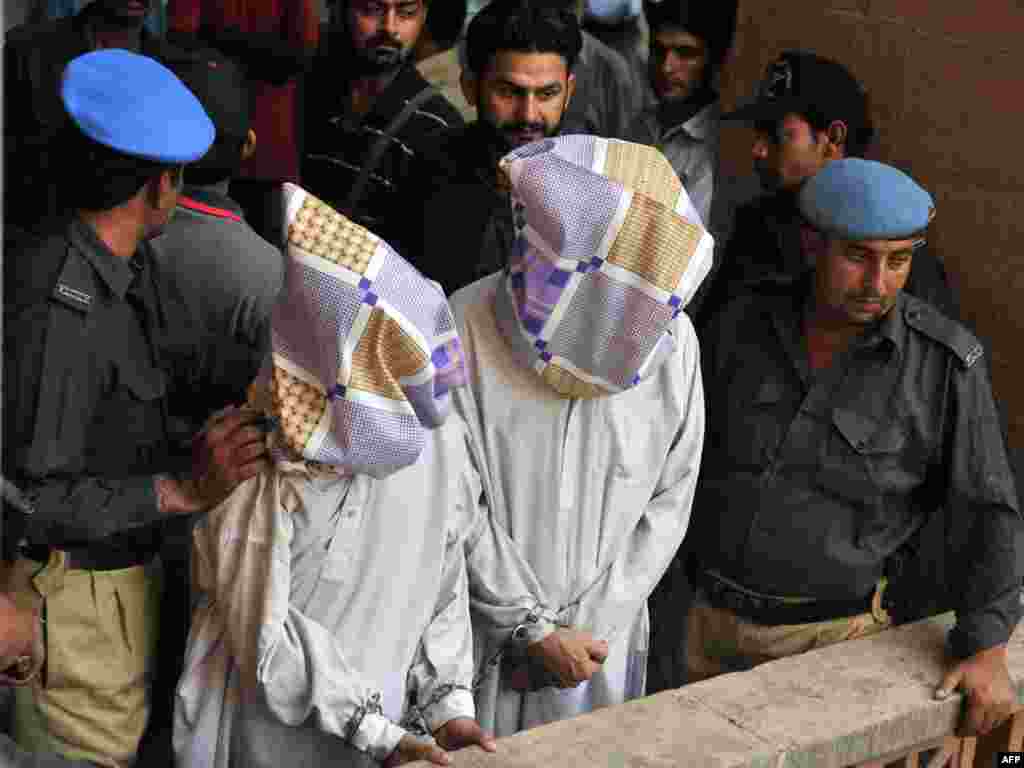 Pakistan -- Policemen escort two suspected members of the country's feared Tehrik-e-Taliban Pakistan (TTP) to a court room in Karachi, 20Oct2009 - PAKISTAN, Karachi : Pakistani policemen escort two suspected members of the country's feared Tehrik-e-Taliban Pakistan (TTP) to a court room in Karachi on October 20, 2009.