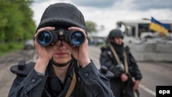 A Ukrainian soldier uses his binoculars at a checkpoint not far of Slovyansk on May 5.