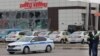 Police officers stand guard in front of a damaged store at the scene of fresh aerial attacks on Belgorod, Russia, on March 14.