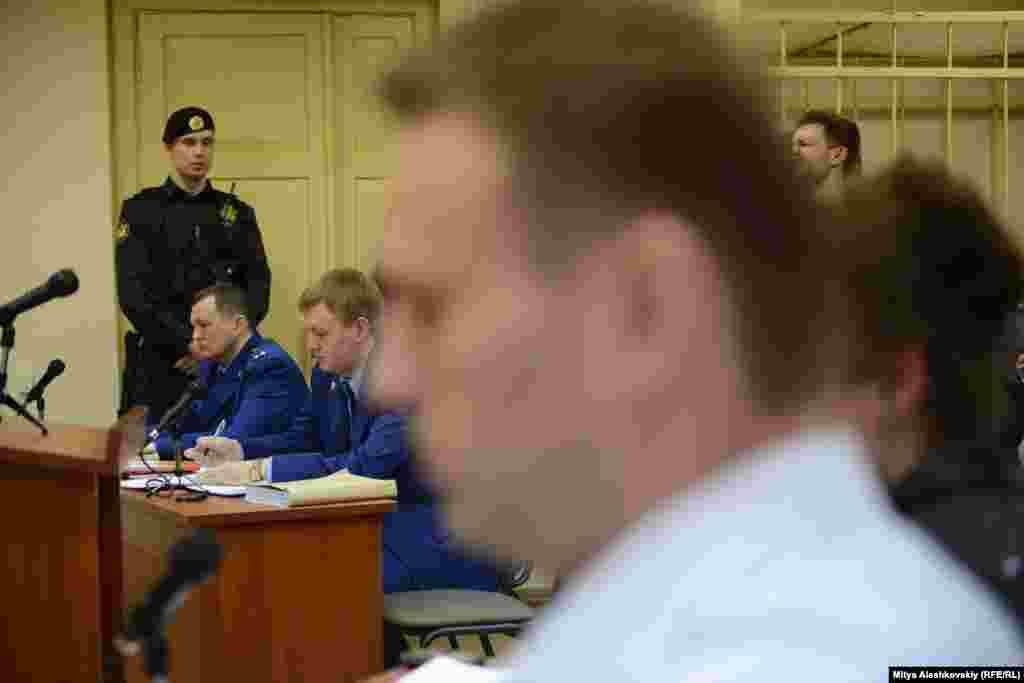 Навальный сидел за столиком рядом с адвокатами, а не в клетке, поскольку не был заключен под стражу