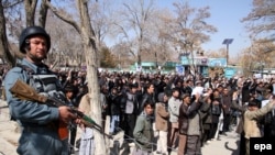 Сотрудник афганских сил безопасности наблюдает за акцией протеста хазарейцев против похищений представителей этой общины. Газни, 17 марта 2015 года. Иллюстративное фото.