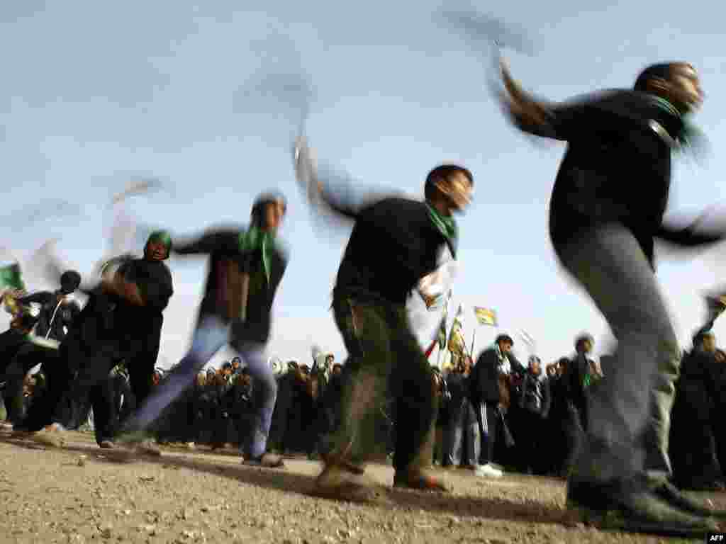 Iraqi Shi'ite men flagellate themselves outside a mosque in central Baghdad on December 16 &nbsp;during Ashura commemorations&nbsp; marking the seventh-century killing of Imam Hussein, the grandson of Prophet Muhammad, in the Battle of Karbala in central Iraq. Photo by Sabah Arar for AFP