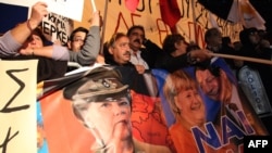 Posteri Angele Merkel i predsjednika Kipra Nikosa Anastasiadesa na protestima na Kipru