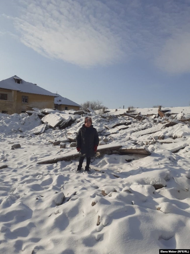 Жительница переселяемого поселка Жезказган (в народе — Рудник) Тамара Децур на фоне снесенного дома, где была ее квартира. 20 декабря 2020 года.