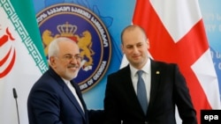 Georgian Foreign Minister Mikheil Janelidze (right) welcomes his Iranian counterpart Mohammad Javad Zarif in Tbilisi.