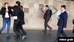 На кадре из видео — член правительственной делегации Таджикистана бьет сторонника оппозиции Сулаймони Орзу. Варшава, 11 сентября 2018 года.