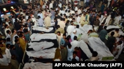 Pakistani relatives gather around the bodies of blast victims after a suicide bomb attack near the Wagah border on November 2, 2014.
