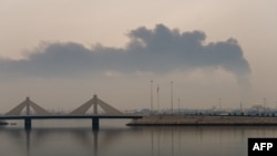 Столб дыма поднимается после сообщения об иранском ударе по топливным резервуарам в Мухарраке, 12 марта 2026 года.