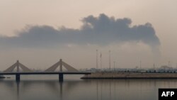 Un nor de fum se ridică în urma unui presupus atac iranian cu dronă asupra rezervoarelor de combustibil din Muharraq, pe 12 martie 2026.