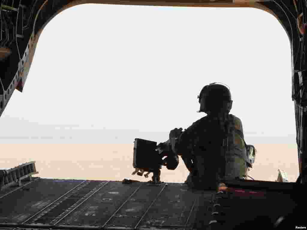 A U.S. soldier mans a machine gun at the rear of a U.S. military helicopter during a mission in Kandahar Province, southern Afghanistan, on October 1. Photo by Erik de Castro for Reuters