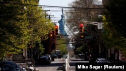 Străzi aproape pustii în Jersey City dominate de Statuia Libertății