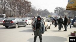 Members of the Afghan police stand guard at a checkpoint in Kabul on February 18 following a Taliban suicide attack the day before.