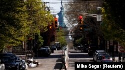 Koronawirus keseli döwründe adamsyz galan köçäniň aýagyndan görünýän Azatlyk heýkeli. Jersiý şäheri, Nýu-Ýork.