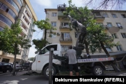 A boom truck outside an apartment building with a covered balcony in Bishkek on June 26.
