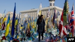 A woman reads inscriptions at a makeshift memorial on Kyiv's Independence Square for Ukrainian and foreign fighters who have fallen during Russia's invasion, on the third anniversary of the start of the all-out conflict on February 24. 