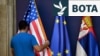 Një punonjës rregullon flamurin amerikan pranë flamurit të BE-së dhe atij serb, në prag të një konference të përbashkët për shtyp të zyrtarëve serbë dhe amerikanë në Beograd, nëntor 2019.