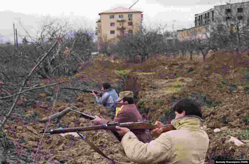 Oszét férfiak Chinvali külvárosában. Fegyverként elavult orosz puskákat használtak, amelyeket az 1890-es években készítettek. 1991 folyamán etnikai hovatartozástól függetlenül kegyetlen gyilkosságok és vérengzések történtek grúz és oszét falvakban egyaránt.