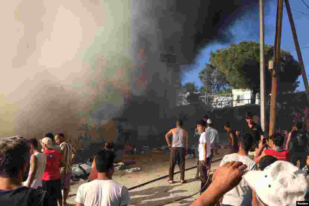 Migrantët duke shikuar zjarrin që përfshiu kampin Moria në Lesbos të Greqisë. 