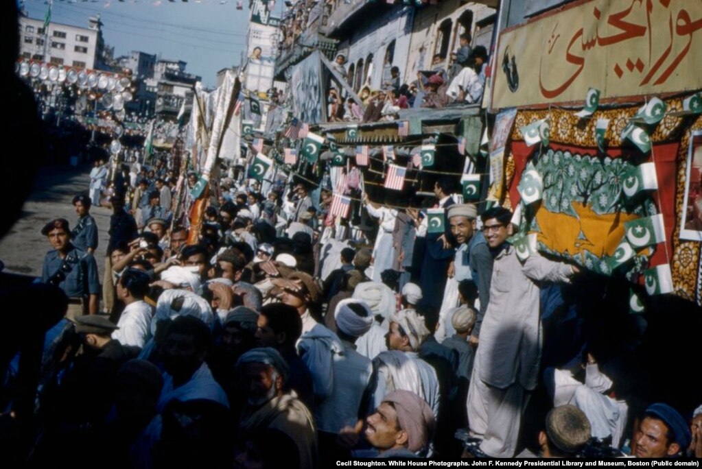 Crowds line a street in Peshawar to welcome the American first lady.