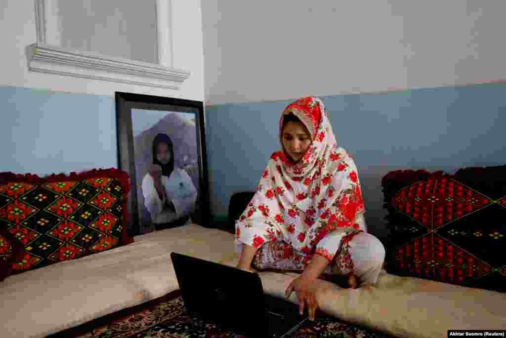 Nargis Hazara, 20, martial arts specialist, who belongs to ethnic Hazara community, works on her computer as she sits beside her portrait at her home in Hazara Town, Quetta, Pakistan, June 13, 2019. Domestic media often portray the Hazaras as targets of sectarian attacks or holding sit-ins to demand greater protection, but the community is developing and growing, said Nargis, who last year became Pakistan's first winner of an Asian Games medal in karate. "Every one of us has a dream, a target and aim in our heart, to change the image of Hazaras in the world, and especially in Pakistan."