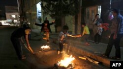 Iranian families light fire outside their houses in Tehran on March 13, 2018 during the Wednesday Fire feast, or Chaharshanbeh Soori, held annually on the last Wednesday eve before the Spring holiday of Noruz. The Iranian new year that begins on March 20