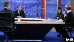 Russian Prime Minister Dmitry Medvedev (left) being interviewed by Russian TV channels