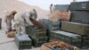 IS fighters search weapons boxes at a Russian base in what is said to be Palmyra, in this still image taken from video uploaded to social media on December 13.