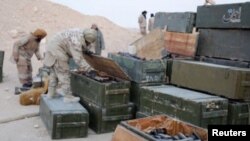 Islamic State fighters search weapons boxes at a Russian base in what is said to be Palmyra, in this still image taken from video uploaded to social media on December 13.