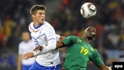 Еуропа чемпионаты іріктеуінде 12 гол салған футболшы Клаас-Ян Хунтелаар (сол жақта) Камерун ойыншысы Стефан Мбиаға қарсы ойнап жүр. Кейптаун, 24 маусым 2010 жыл.